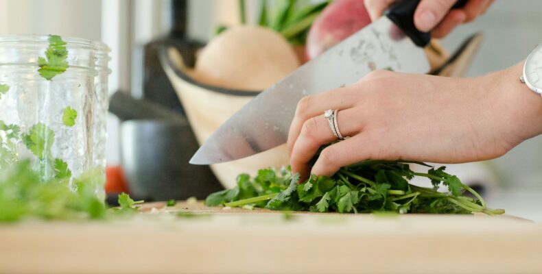 person cutting vegetables with knife